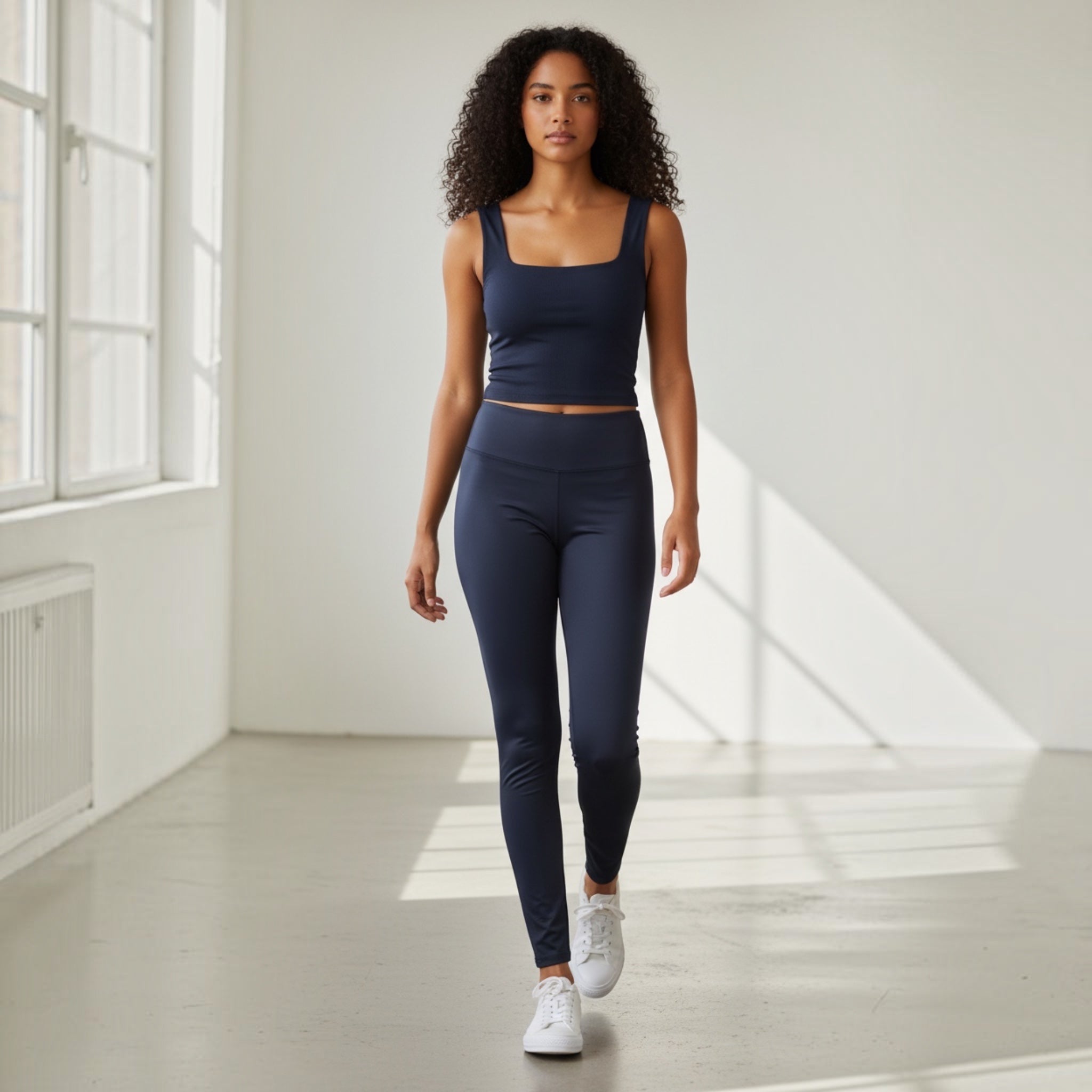 Woman wearing navy blue activewear leggings and vest