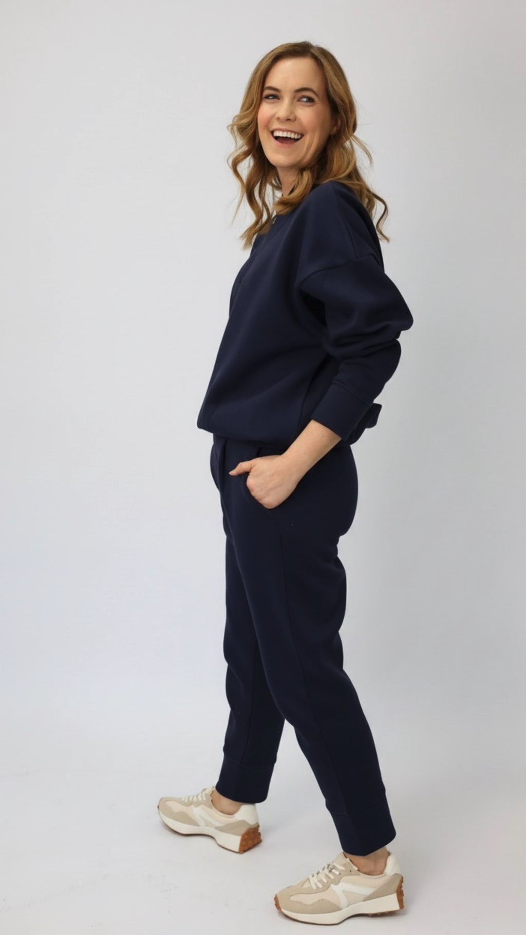 Model wearing a navy tracksuit with white sneakers