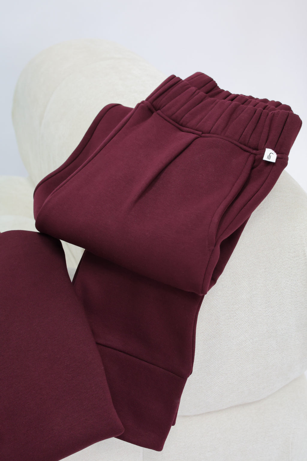 Detailed view of burgundy joggers with Wild Geese brand label