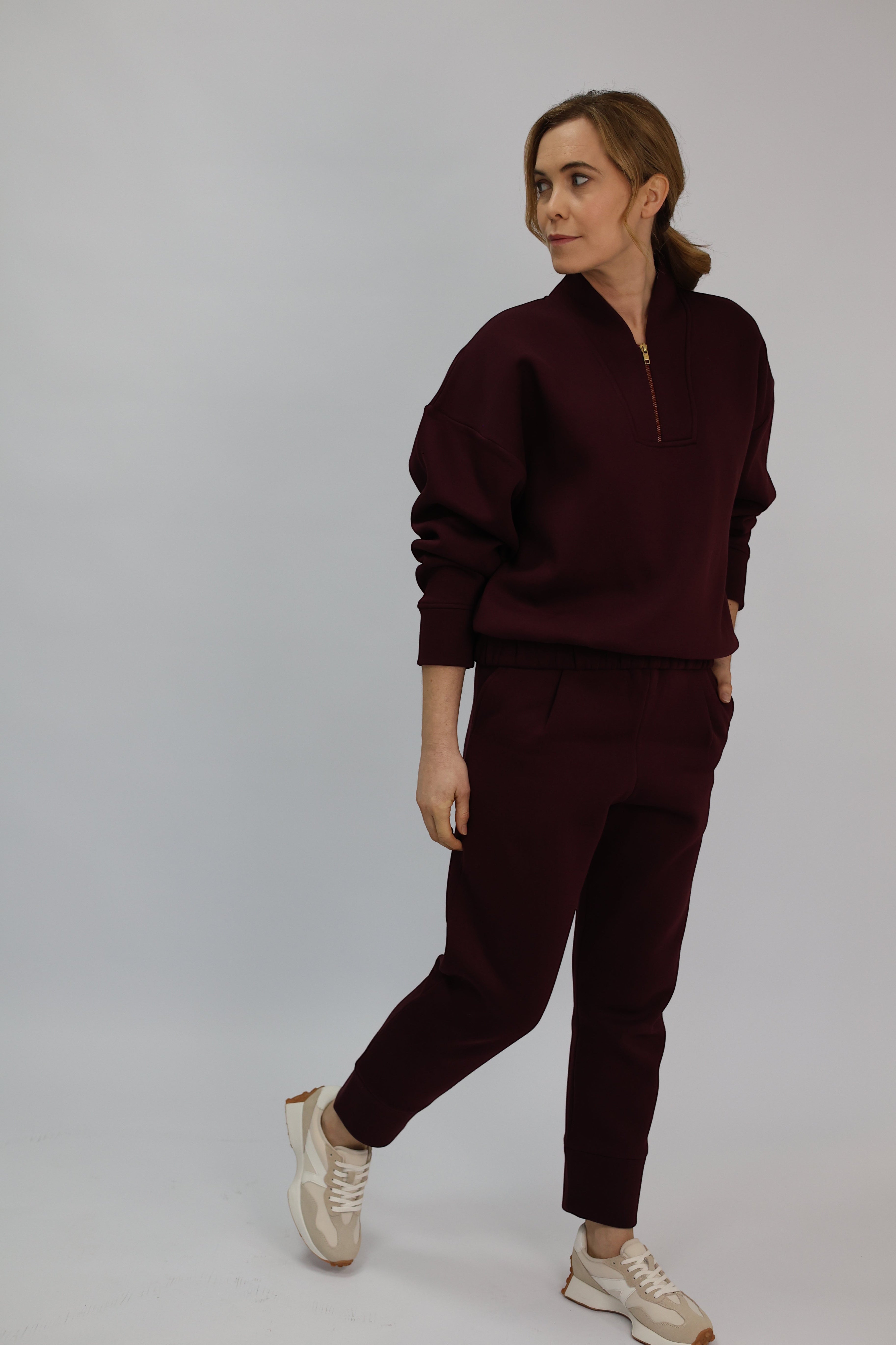 Wild Geese Margot Relaxed Cigarette Sweatpants in burgundy, made from 100% cotton with fleece lining. Features front pleats and a tapered leg.