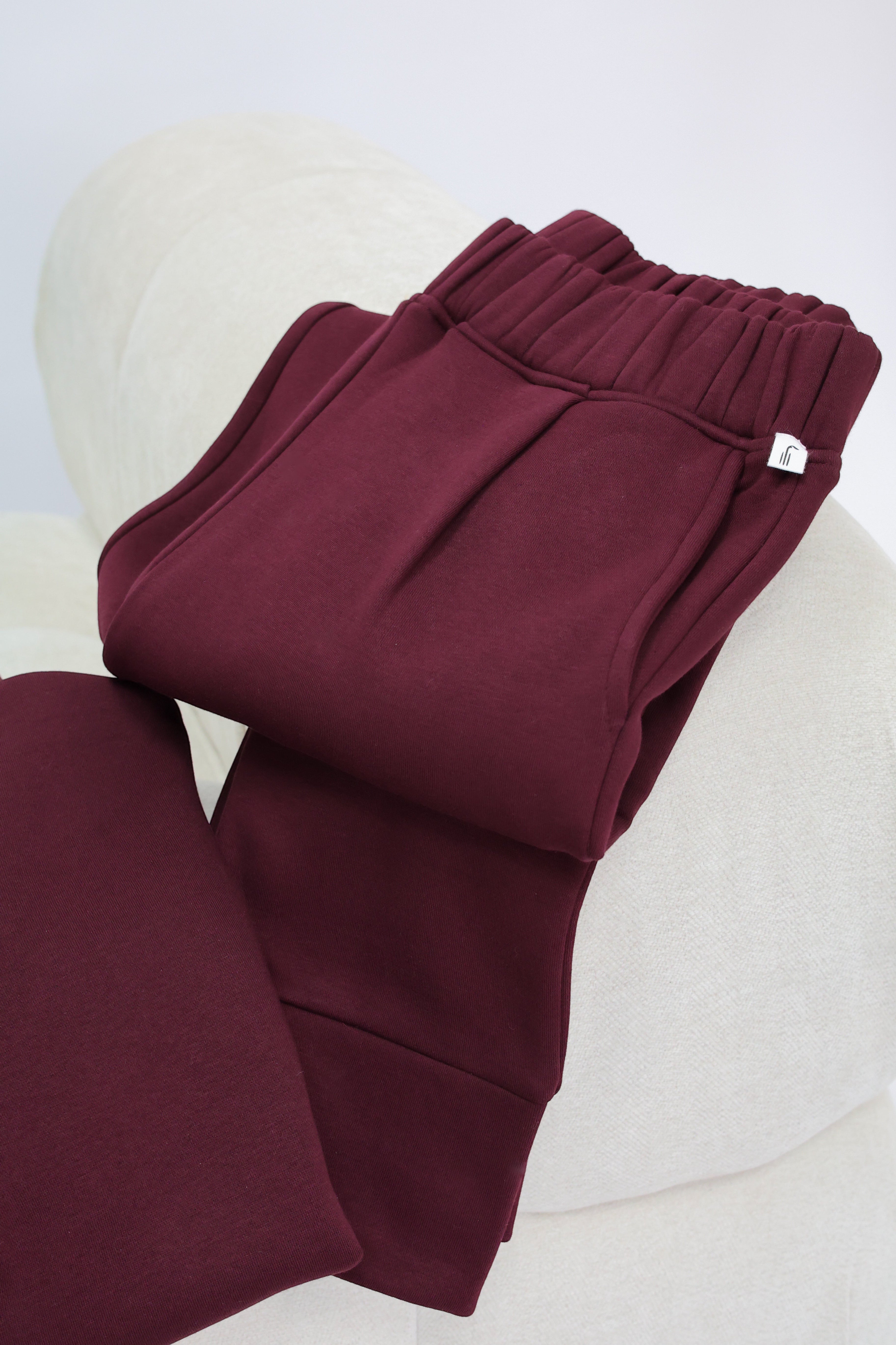 Wild Geese Margot Relaxed Cigarette Sweatpants in burgundy cotton with fleece lining and front pleats.